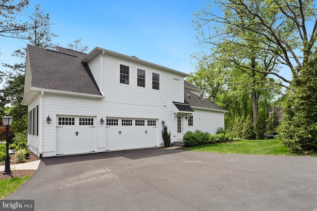 9850 Jerry Ln, Vienna, VA 22180 - view of front of house with asphalt driveway, a shingled roof, a front yard, and an attached garage