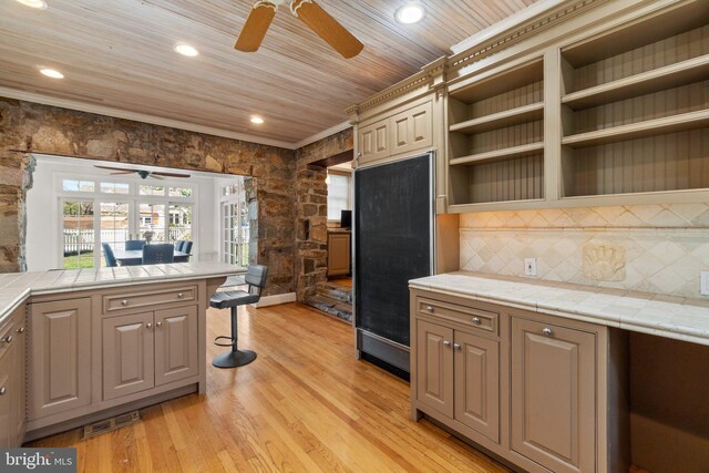 65 W Green St, Westminster, MD 21157 - kitchen featuring light wood-style floors, a ceiling fan, a breakfast bar, and tasteful backsplash