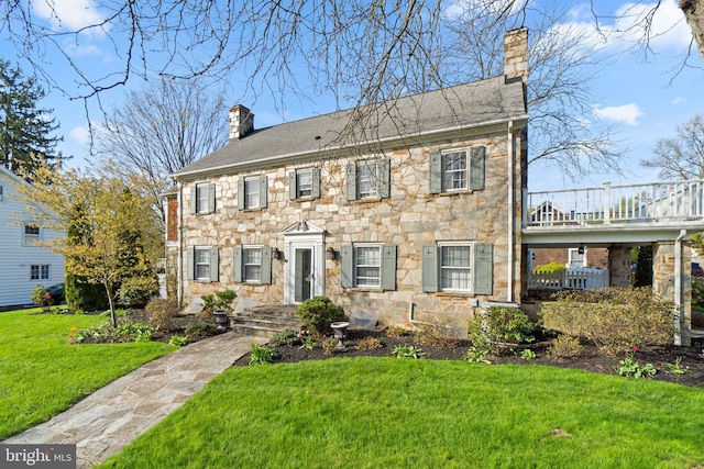 65 W Green St, Westminster, MD 21157 - colonial house featuring a balcony, a chimney, a front lawn, and stone siding