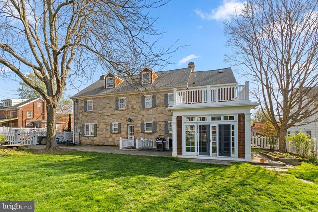 65 W Green St, Westminster, MD 21157 - rear view of house with fence, stone siding, a balcony, a lawn, and a patio