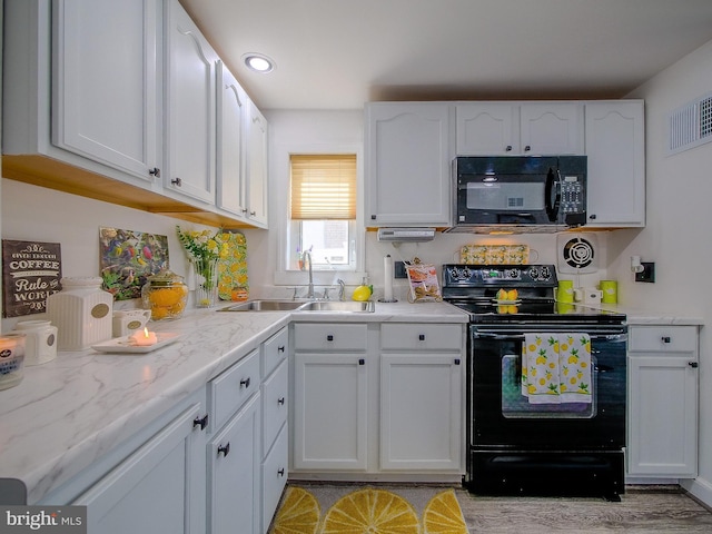 112 Jackson Ave, New Castle, DE 19720 - kitchen with black appliances, a sink, white cabinets, and visible vents