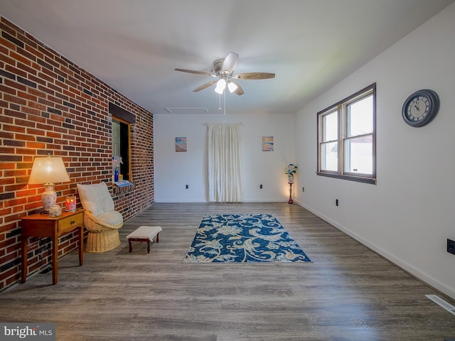 112 Jackson Ave, New Castle, DE 19720 - sitting room with a ceiling fan, baseboards, wood finished floors, and brick wall