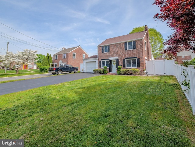 112 Jackson Ave, New Castle, DE 19720 - view of front of house with a chimney, brick siding, fence, aphalt driveway, and a front lawn