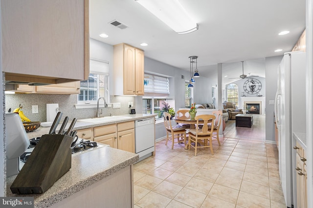 kitchen with a wealth of natural light, a sink, visible vents, white appliances, and light brown cabinets