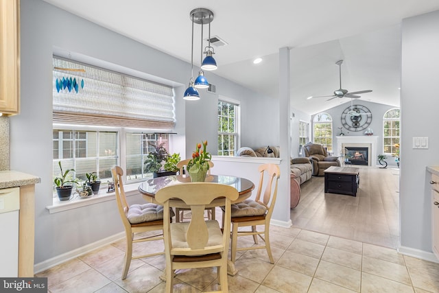 dining room featuring vaulted ceiling, visible vents, a ceiling fan, baseboards, and a glass covered fireplace