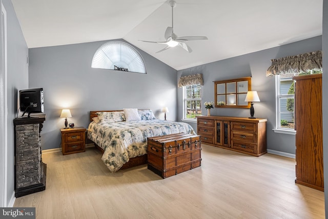 bedroom with vaulted ceiling, wood finished floors, and baseboards