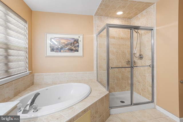 bathroom with tile patterned flooring, a tub with jets, and a stall shower