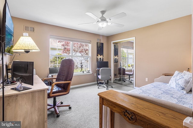 carpeted bedroom with baseboards, a ceiling fan, and visible vents