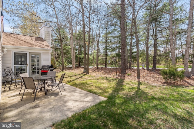 view of yard featuring outdoor dining space and a patio