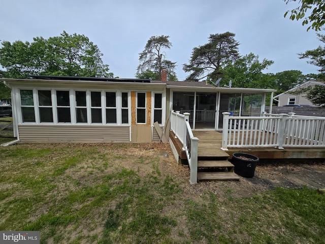 401 Timberline Dr, Mount Laurel, NJ 08054 - view of front facade featuring a sunroom, a chimney, a deck, and roof mounted solar panels