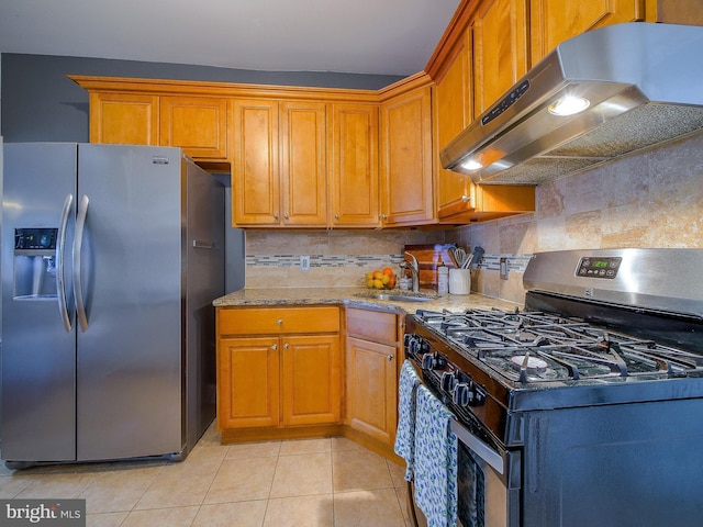 2905 Memphis St, Philadelphia, PA 19134 - kitchen featuring under cabinet range hood, light tile patterned floors, a sink, tasteful backsplash, and appliances with stainless steel finishes