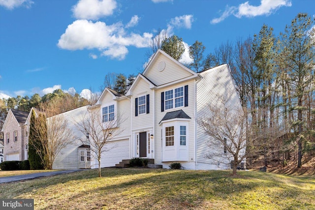 traditional home featuring aphalt driveway, a front yard, and an attached garage