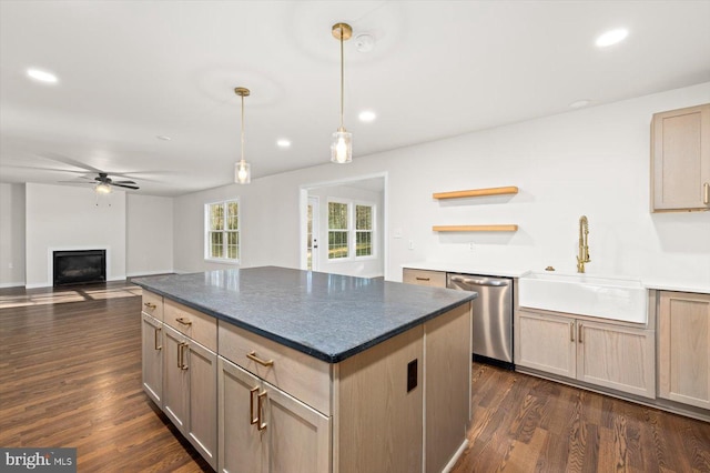 kitchen with a fireplace, dark wood-type flooring, ceiling fan, stainless steel dishwasher, and a sink