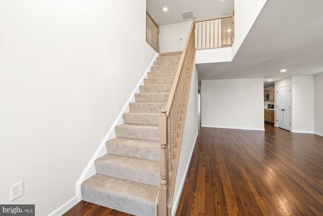 stairway with recessed lighting, visible vents, baseboards, and wood finished floors