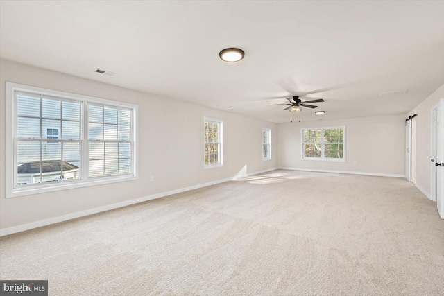 empty room with light carpet, baseboards, and a ceiling fan