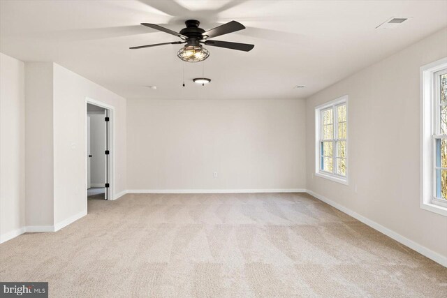 spare room with visible vents, baseboards, a ceiling fan, and carpet floors