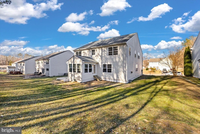 back of house featuring a yard and a sunroom