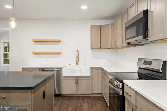 kitchen with decorative light fixtures, a sink, appliances with stainless steel finishes, dark wood-style floors, and recessed lighting