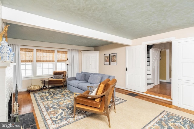 442 Ellisdale Rd, Crosswicks, NJ 08515 - living room featuring a fireplace, wood-type flooring, a textured ceiling, and baseboards