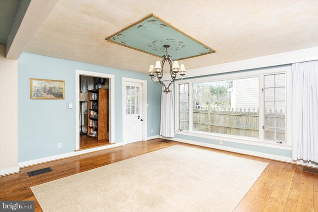 442 Ellisdale Rd, Crosswicks, NJ 08515 - unfurnished dining area with wood-type flooring, baseboards, and an inviting chandelier