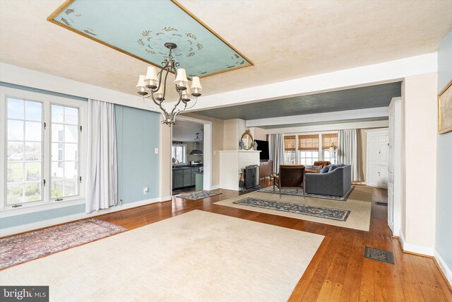 442 Ellisdale Rd, Crosswicks, NJ 08515 - living room featuring wood-type flooring, a fireplace, a notable chandelier, and baseboards