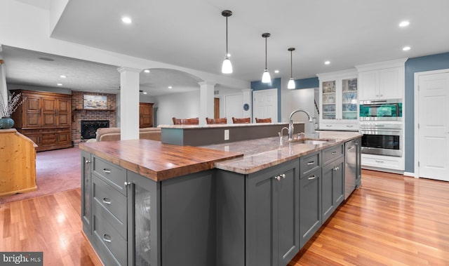116 Amesbury Ct, Severna Park, MD 21146 - kitchen with ornate columns, gray cabinetry, stainless steel appliances, wooden counters, and a fireplace