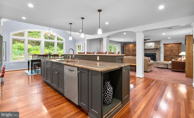 116 Amesbury Ct, Severna Park, MD 21146 - kitchen featuring stainless steel dishwasher, ornate columns, a sink, a fireplace, and light wood finished floors