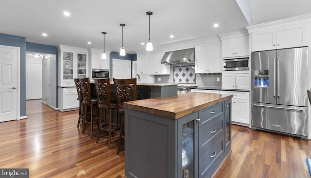 116 Amesbury Ct, Severna Park, MD 21146 - kitchen featuring stainless steel appliances, wood counters, a center island, wall chimney exhaust hood, and white cabinetry