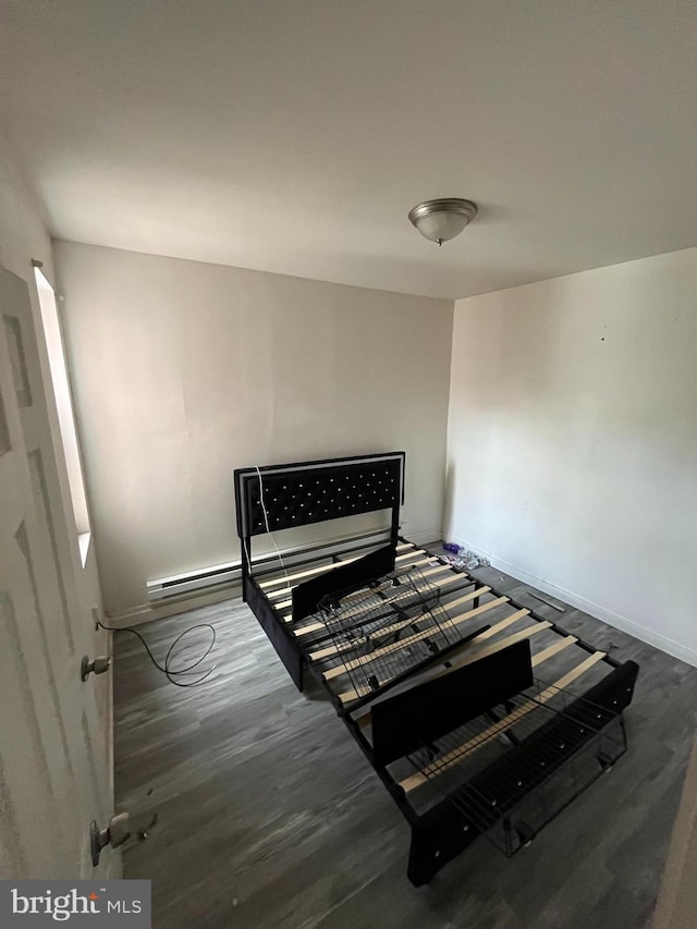 bedroom featuring a baseboard radiator, wood finished floors, and baseboards