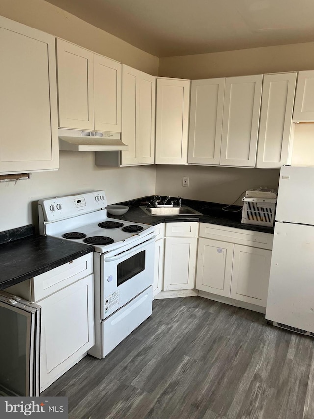 kitchen with white cabinets, a sink, under cabinet range hood, dark wood finished floors, and white appliances