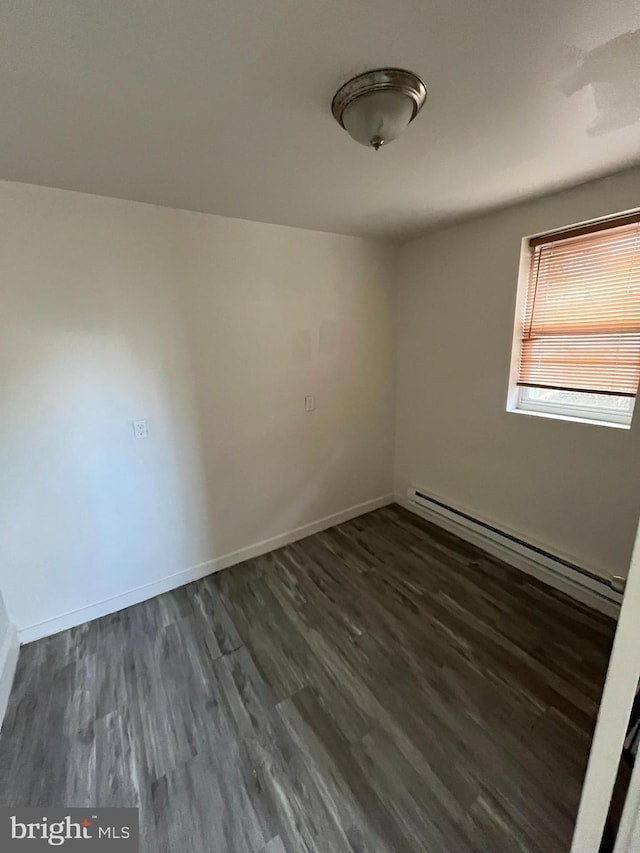 unfurnished room with baseboard heating, baseboards, and dark wood-type flooring