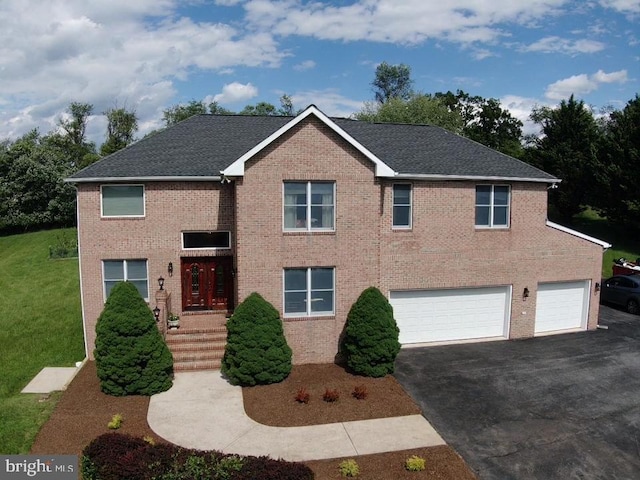 view of front of house featuring driveway, an attached garage, a front lawn, brick siding, and roof with shingles