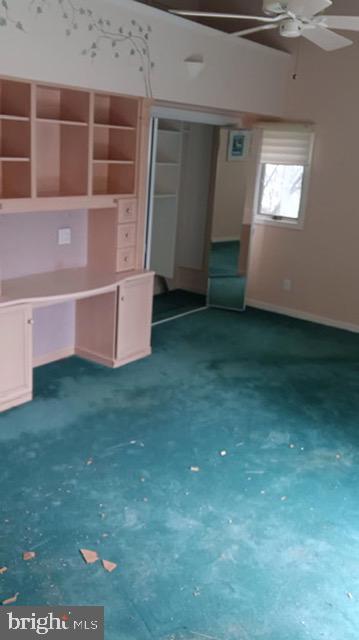 interior space with ceiling fan and baseboards