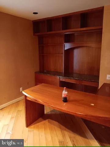 unfurnished office featuring light wood-style flooring and baseboards