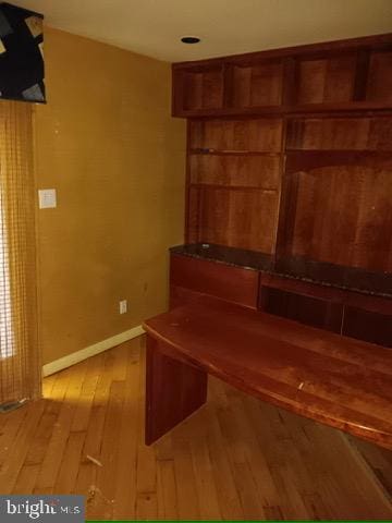interior space with baseboards and light wood finished floors