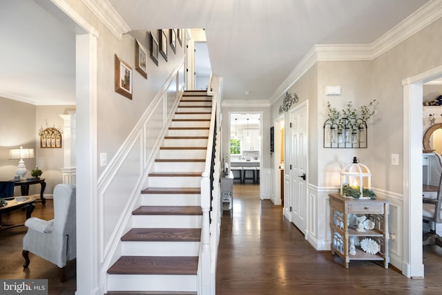 15014 Plastron Ct, Woodbridge, VA 22193 - stairs featuring wood finished floors, a decorative wall, crown molding, and a wainscoted wall