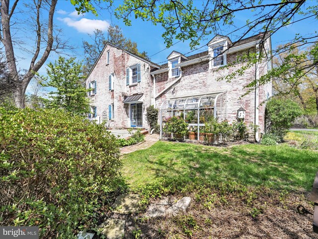 view of front of property featuring a front yard and brick siding