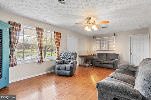 10257 Back Creek Valley Rd, Hedgesville, WV 25427 - living room featuring visible vents, light wood-style floors, baseboards, a textured ceiling, and ceiling fan