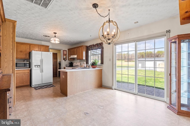 10257 Back Creek Valley Rd, Hedgesville, WV 25427 - kitchen with a peninsula, stainless steel microwave, an inviting chandelier, stove, and white fridge with ice dispenser