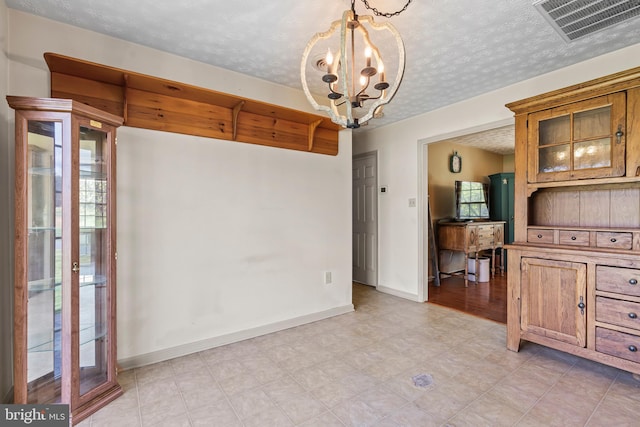10257 Back Creek Valley Rd, Hedgesville, WV 25427 - unfurnished dining area featuring an inviting chandelier, a textured ceiling, visible vents, and baseboards
