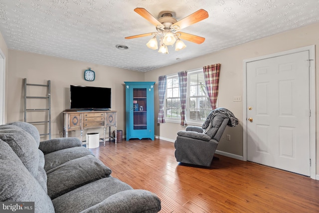 10257 Back Creek Valley Rd, Hedgesville, WV 25427 - living area featuring light wood finished floors, a textured ceiling, baseboards, visible vents, and a ceiling fan