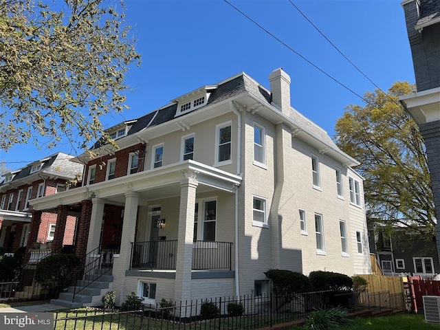 512 Peabody St NW, Washington, DC 20011 - view of home's exterior featuring brick siding, mansard roof, and a fenced front yard
