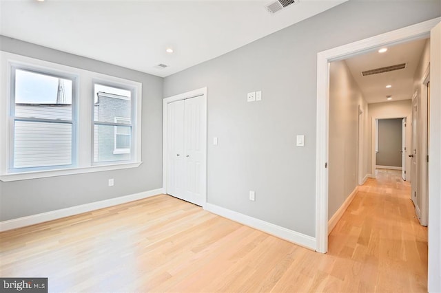 512 Peabody St NW, Washington, DC 20011 - unfurnished bedroom featuring light wood-style floors, a closet, baseboards, and visible vents