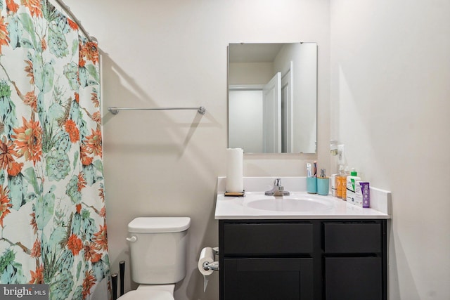 bathroom featuring toilet, vanity, and a shower with shower curtain