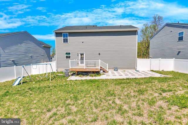 rear view of property with a yard, a patio area, a fenced backyard, and a deck