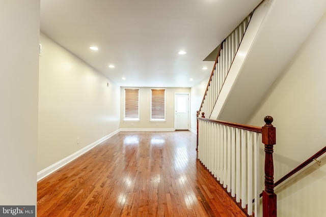 corridor featuring recessed lighting, light wood-style flooring, and baseboards