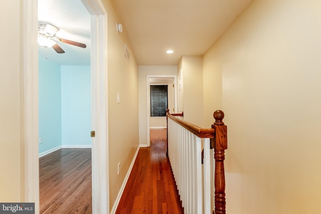 corridor with baseboards, recessed lighting, an upstairs landing, visible vents, and wood finished floors