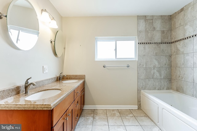 bathroom with tile patterned floors, double vanity, baseboards, and a sink
