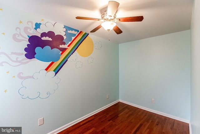 unfurnished room with dark wood-type flooring, ceiling fan, and baseboards