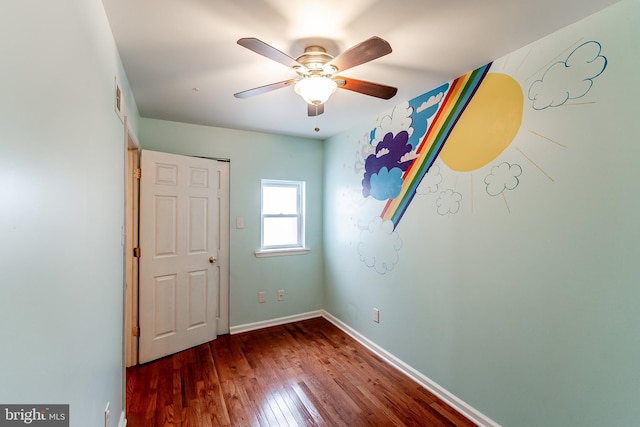 unfurnished room with visible vents, baseboards, a ceiling fan, and hardwood / wood-style flooring